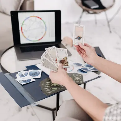 Des cartes posées à côté d'un thème astral imprimé
